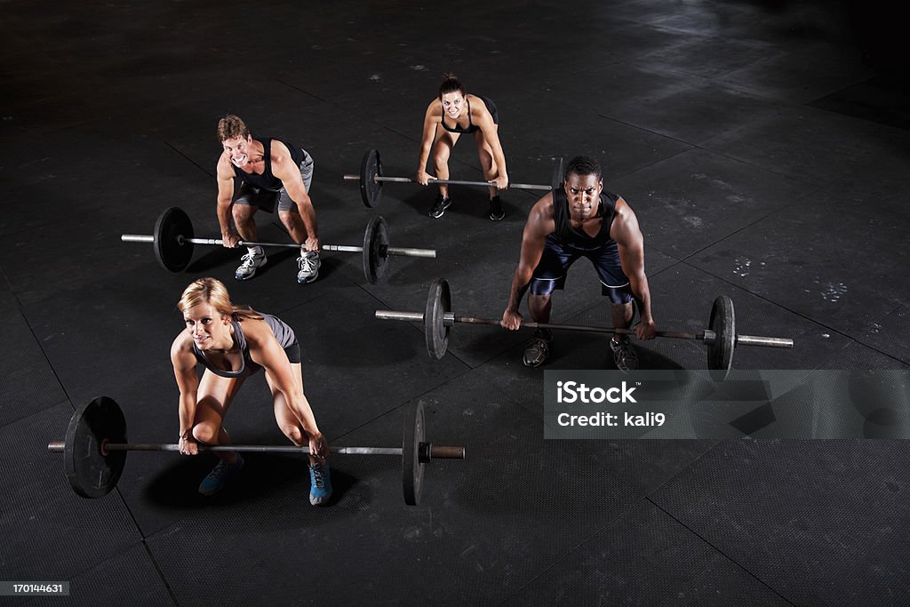 Group of body builders lifting barbells Multi-ethnic group of body builders lifting barbells. Coach Stock Photo