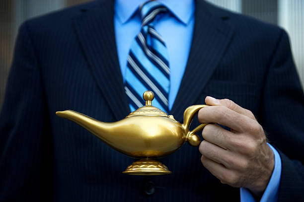 Businessman holds golden magic lamp up for the camera