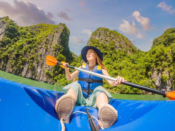 Mom, dad and son travelers rowing on a kayak in Halong Bay. Vietnam. Travel to Asia, happiness emotion, summer holiday concept. Traveling with children concept. After COVID 19. Picturesque sea landscape. Ha Long Bay, Vietnam. mamá, papá e hijo viajeros remando en un kayak en la bahía de halong. vietnam. viaje a asia, emoción de felicidad, concepto de vacaciones de verano. concepto de viajar con niños. después de covid 19. pintoresco paisaje marino. bahía de ha long, viet