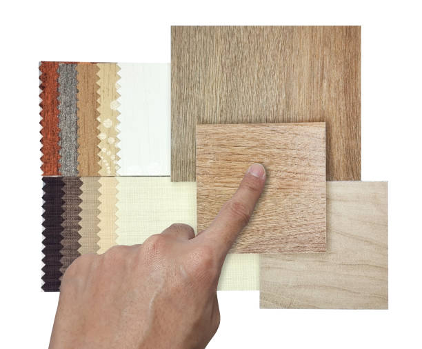 istock designer's hand chooses interior material samples contains oak wooden ceramic flooring tiles and drapery fabric catalog palette in luxury brown color tone isolated on background with clipping path. 1701470697