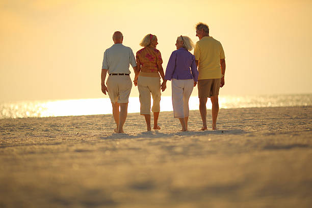 istock Group of happy Seniors walking on beach at sunset 170149955