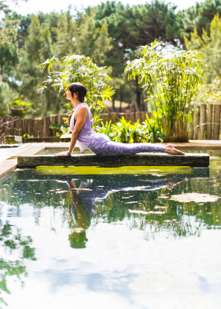 istock Woman practicing yoga, lying in Cobra pose (Bhujangasana exercise) outdoors. Vertical shot. 1701505892