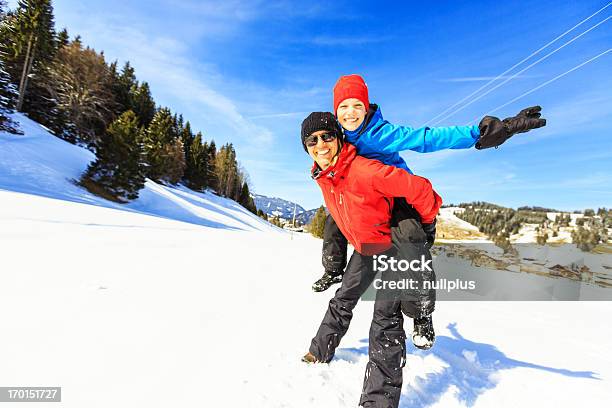 Mulher Madura E Filha Piggybacking - Fotografias de stock e mais imagens de Inverno - Inverno, 40-49 Anos, Abraçar