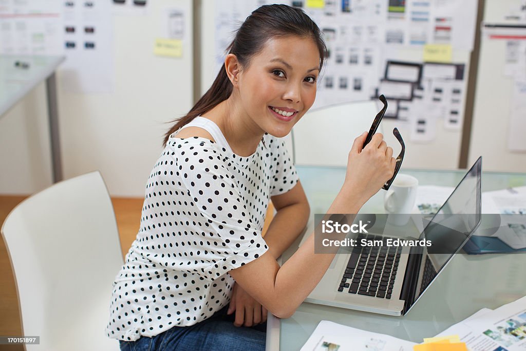 Souriant Femme d'affaires avec ordinateur portable dans le bureau - Photo de 25-29 ans libre de droits