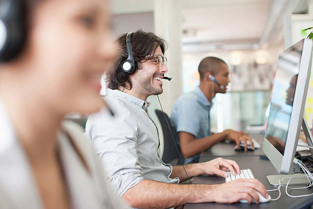 pessoas de negócios com auscultadores trabalhando em computadores no escritório - wireless technology professional occupation people day imagens e fotografias de stock