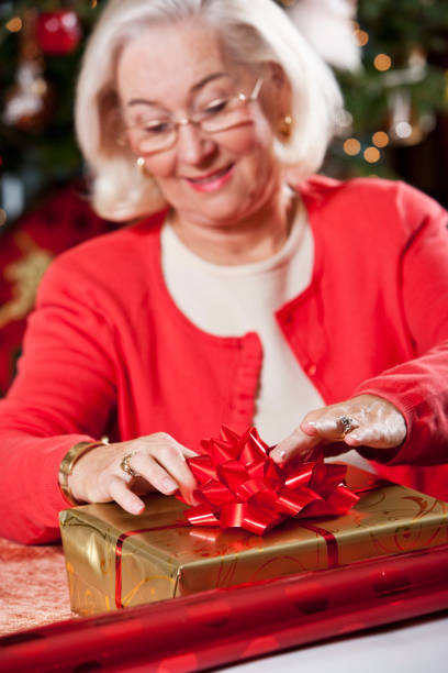 istock Grandma wrapping Christmas gifts by tree 170153885