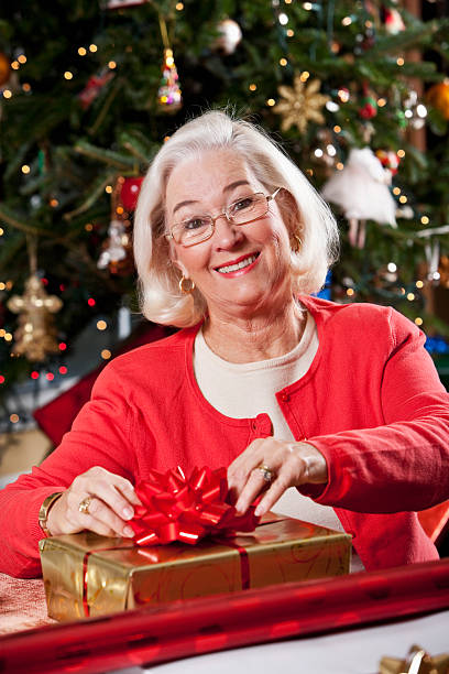 istock Grandma wrapping Christmas gifts by tree 170153930