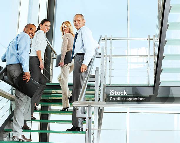 Grupo De Empresarios La Gente Sonriente En La Escalera De Caracol Foto de stock y más banco de imágenes de Escaleras