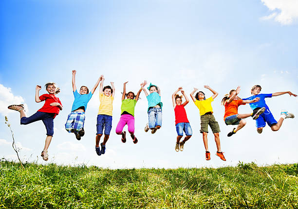 alegre grupo de crianças de salto contra o céu. - human age multi ethnic group variation group of people imagens e fotografias de stock