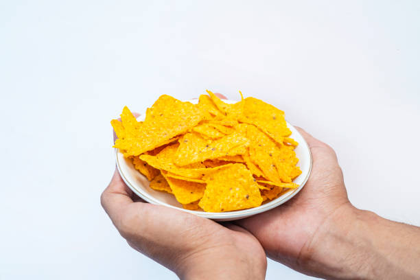 istock A human hand holding a plate with tortilla chips 1701561982