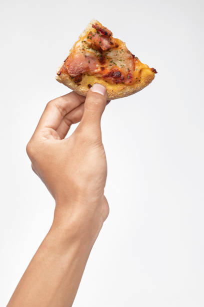 istock A human hand holding a slice of pizza 1701575313