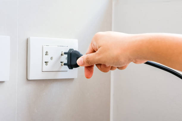 spina di tenuta manuale collegare a una spina di alimentazione in una presa elettrica su una parete, presa di corrente, concetto di risparmio energetico, risparmio energetico, risparmio energetico. - electric plug outlet human hand electricity foto e immagini stock