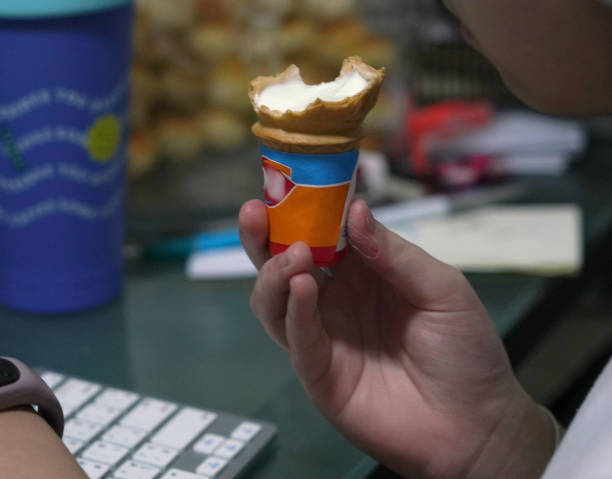 hand hold ice cream wafer cone indoors,close up
