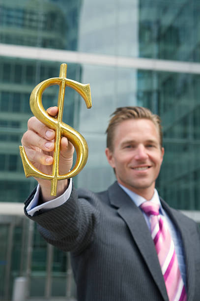 istock Smiling Businessman Holds Golden Dollar Sign 170160929
