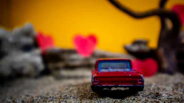 Minahasa, Indonesia : December 2022, toy car with gradient orange and hearts background