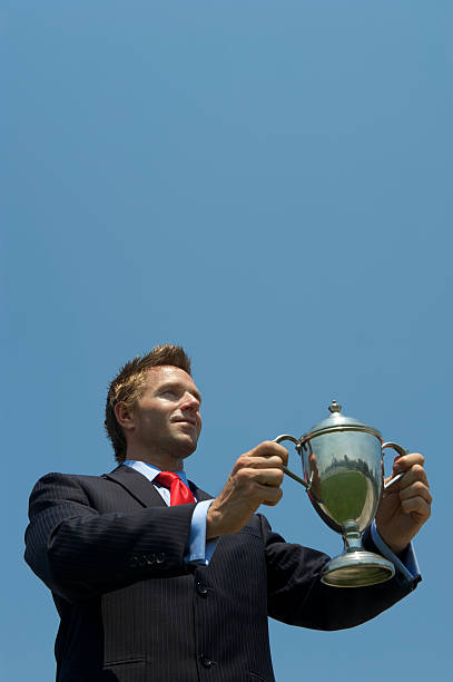 istock Proud Businessman Holding Silver Trophy Blue Sky 170162033