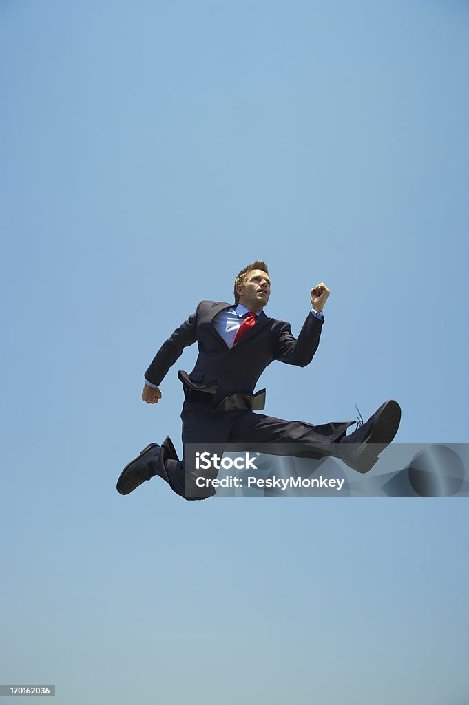 Jeune homme d'affaires de sauter en plein air haut dans le ciel bleu - Photo de Course de haies - Course sur piste libre de droits