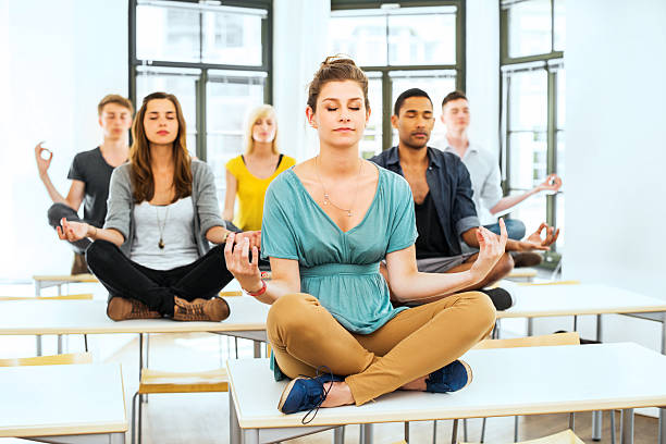 istock Large group of students meditating on the desks. 170162086