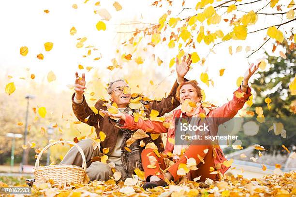 Cheerful Mature Couple On A Picnic In Nature Stock Photo - Download Image Now - Senior Adult, Autumn, Orange Color