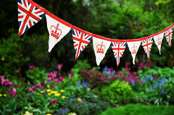 union jack bunting bunte englischen garten feiern royal baby - jubilee bunting british flag flower bed stock-fotos und bilder