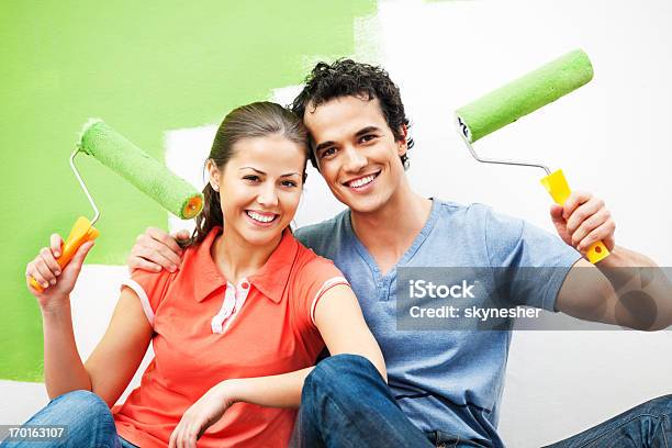 Cheerful Couple Painting The Wall Stock Photo - Download Image Now - Adult, Adults Only, Beautiful People