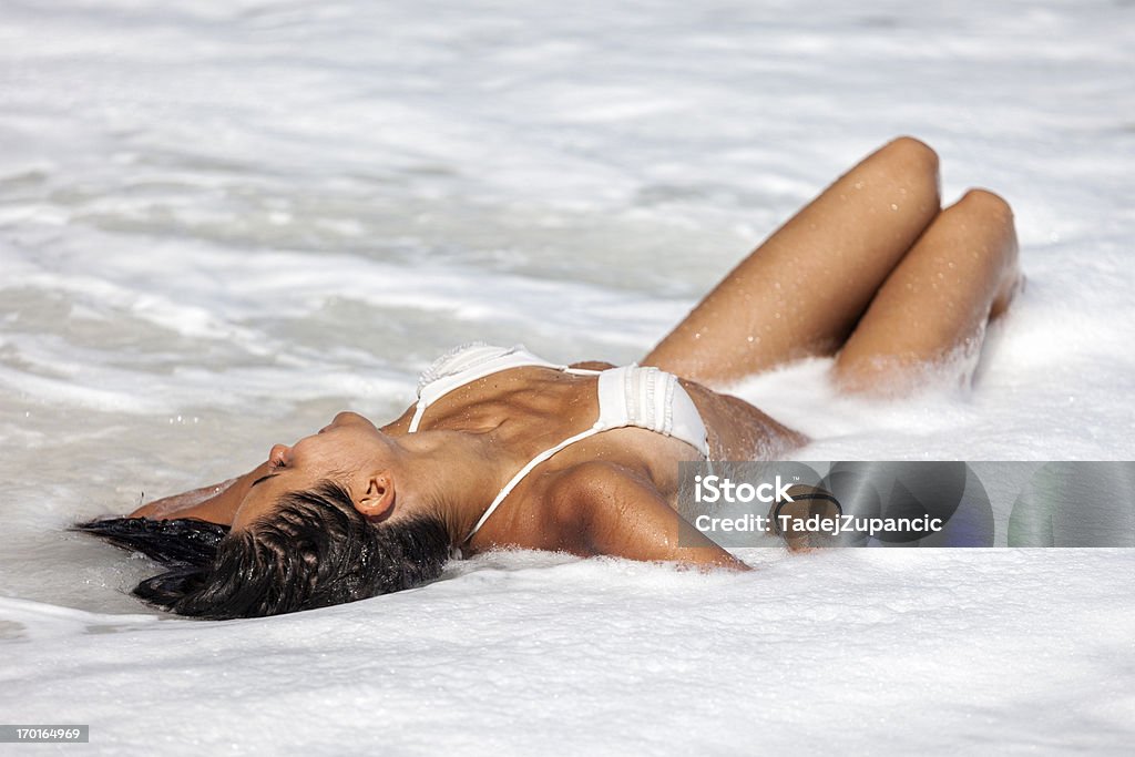 Young woman lying en la playa - Foto de stock de Acostado libre de derechos