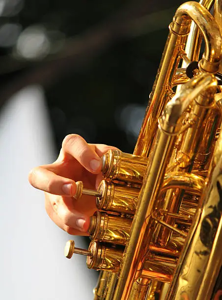Tuba brass instrument an a hand of a player.