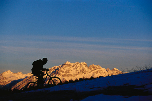 A male mountain biker rides a trail in the wintertime in Alberta, Canada.