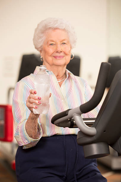 feliz mulher sênior exercitar-se na esteira na academia de ginástica - 65 70 age - fotografias e filmes do acervo