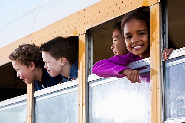 bambini guardando fuori scuola bus finestra - sc0536 foto e immagini stock