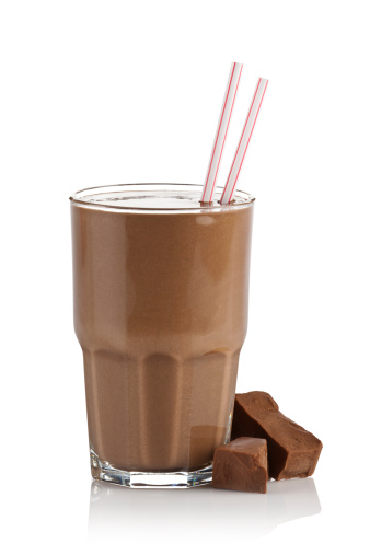 Chocolate Milk Shake Smoothie with Chocolate Chunks on Reflective White Background.