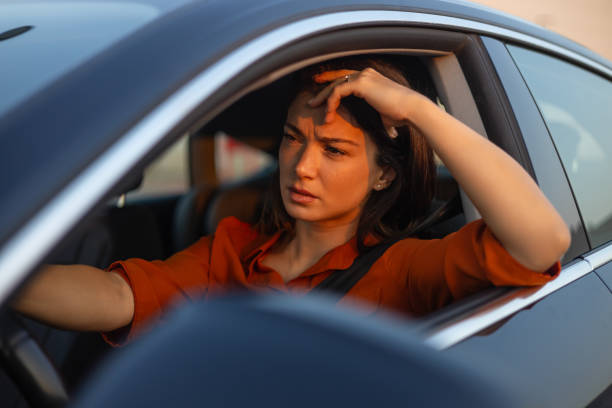 istock Nervous female driver sits at wheel, has worried expression as afraid to drive car by herself for first time. Frightened woman has car accident on road. People, driving, problems with transport 1701694582