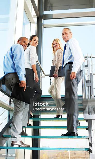 Grupo De Empresarios La Gente Sonriente En La Escalera De Caracol Foto de stock y más banco de imágenes de Personas de negocios