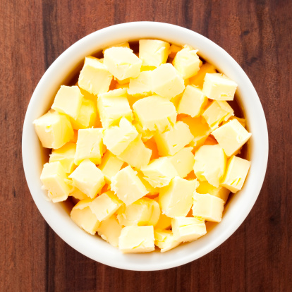 Top view of white bowl full of diced butter