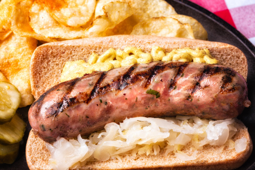 Brat with mustard, chips pickles, and saurkraut