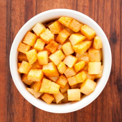 Top view of white bowl full of fried potatoes