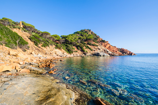 Cala Moresca of Arbatax, a bay protected by red porphyry cliffs covered by Mediterranean scrub with a beach mostly made up of granite pebbles