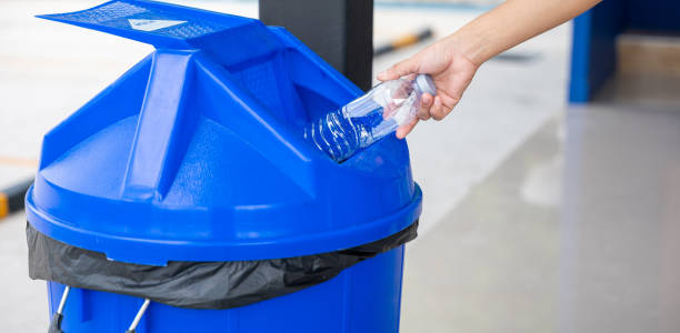 istock Close up woman hand throwing empty plastic water bottle into recycling bin 1701726229