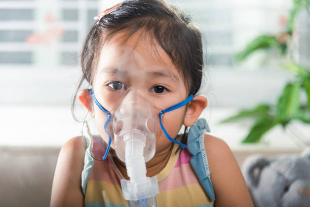 istock Asian Child using nebulizer mask equipment alone have smoke 1701726237
