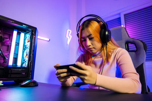 gamer beim spielen von videospielen online mit smartphone mit neonlichtern, über die sie das spiel nicht besteht - gambling loss asian ethnicity depression stock-fotos und bilder