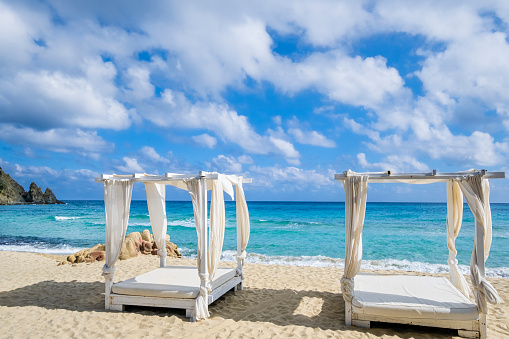 Lounge chairs on the white sand beach of Cala Monte Turno, an enchanting bay that plunges into the crystal-clear sea