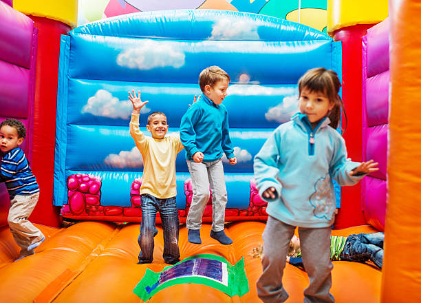 Children in a back garden in summer in the North East of England having a sack race with one another.