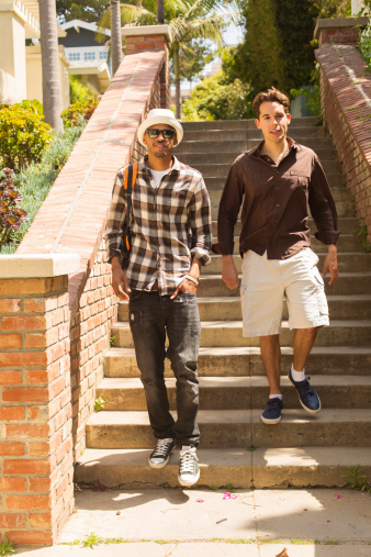 Two young men walking down stairs outside
