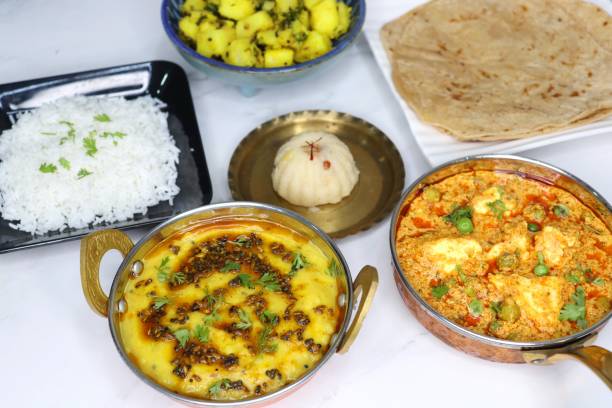 istock Indian vegetarian Thali or platter includes Aloo ki sabji, dal rice, Roti bhaji, Matar Paneer, Sheera or suji ka halwa, chapati. Indian food is served in a Silverplate or thali. Copy Space. Veg Thali 1701755635