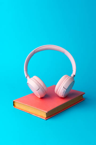 istock Pink headphones on a book on blue background 1701782110