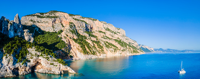 The Monte Caroddi and the imposing cliffs covered with Mediterranean scrub characterize one of the coastal stretches of the Gulf of Orosei, lapped by crystal water (4 shots stitched)