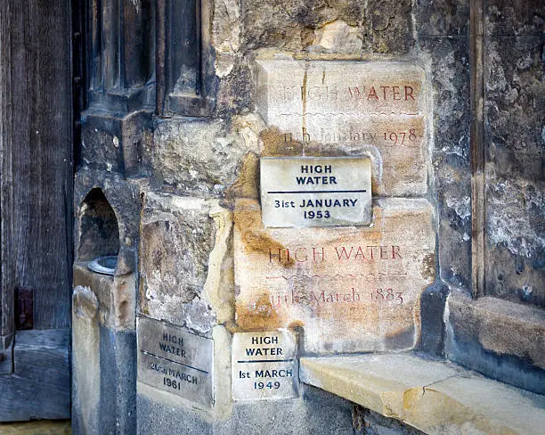 High water marks beside the doorway to St Margaret’s Church, King’s Lynn Minster. They show the levels the flood waters reached on the church fabric in various years. The 1953 floods along the East Coast of England are particularly remembered because of the severe loss of life and damage to property; the flooding was caused by a combination of storm surge, high atmospheric pressure and extra high tides.