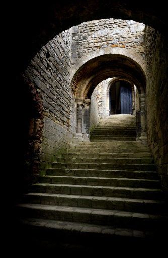 A staircase and archways in a ruined medieval castle.