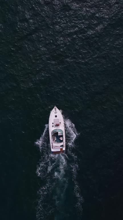 Aerial view of a pleasure boat racing through the sea waves, creating a mesmerizing picture of speed and freedom.