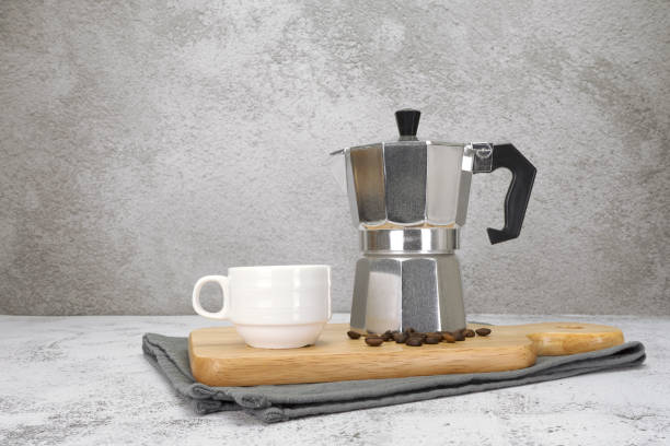 istock Coffee cup with moka pot and wooden tray on texture background. 1701842451